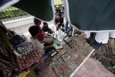 Traders play chess to pass the time while waiting for customers. JP/Boy T. Harjanto
