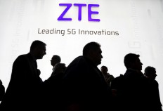Visitors pass in front of the Chinese telecoms equipment group ZTE Corp booth at the Mobile World Congress in Barcelona, Spain, February 26, 2018. 