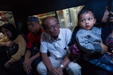 Humble ride: Mangku sits inside a public minivan on his way home after meeting his book publisher. JP/Jerry Adiguna