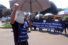 A man wears a white gorilla mask at a rally organized by Sentul City residents on April 30, 2018 against housing developer PT Sentul City's control of the water supply.