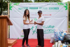 Building bridges for environmental sustainability: Scavenger Indonesia project founder Fio Wibawa (left) symbolically hands over a smartphone to Dartam (right), scavengers coordinator in the Kebayoran Village housing complex area in Bintaro, South Tangerang to mark the launch of the Scavenger application. The waste-recycling management application helps households sort out their trash while connecting them to scavengers who will also sort it out for recycling purposes.