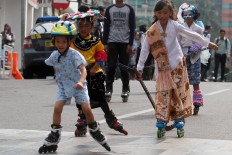 Children roller skate in traditional costumes during the carnival. JP/Arya Dipa