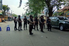 Police officers close the road in front of the National Police Mobile Brigade headquarters (Mako Brimob) in Depok, West Java on Wednesday. At least five officers were reportedly killed in a standoff between the officers and inmates since Tuesday evening.  