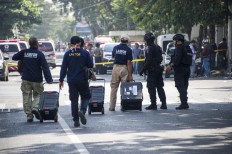 Indonesian policemen carry evidences from the site following a suicide bomb outside a church in Surabaya on May 13, 2018. A wave of blasts including a suicide bombing struck outside churches in Indonesia, killing at least six and wounding dozens of others, police said, the latest assault on a religious minority in the world's biggest Muslim-majority country.  AFP/ Juni Kriswanto