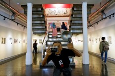 People of different ages and background visit the Antara Photojournalism Gallery to commemorate 20 years of Reformasi in this undated photo.