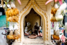 Small porcelain dolls inside a spirit house in Thailand. JP/Anggara Mahendra