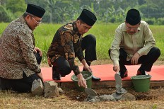 All set: President Joko "Jokowi" Widodo (center), accompanied by then-vice president Jusuf Kalla (right) and then-West Java governor Ahmad Heryawan, lays the cornerstone of the Indonesian International Islamic University (UIII) on June 5, 2018 in Depok, West Java.