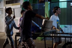 In this photograph taken early on May 19, 2018, youths sing and bang on improvised drums as they walk around their neighborhood to wake up residents for Sahur, the pre-dawn meal eaten before the start of the fasting day throughout the holy month of Ramadan, in Jakarta. 