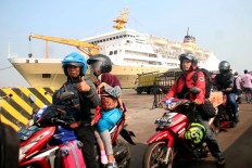 Across the sea: Families ride on motorcycles to their free ferry rides during mudik (exodus). JP/Suherdjoko