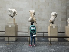 A tourist watches a section of the Elgin Marbles or Parthenon Marbles inside the British Museum in London on April 17, 2014.