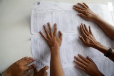 Polling station officials put up the eligible voter list in Kampung Gaga, Larangan, Tangerang regency, Banten, on Tuesday, June 26, 2018. A total of 323 voters were slated to cast their votes at the polling station. JP/Wendra Ajistyatama