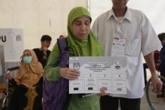 A disabled woman casts her vote in the West Java gubernatorial election at a carnival-themed polling station in Pondok Jaya, Depok, West Java on Wednesday, June 27, 2018. JP/Wendra Ajistyatama