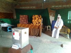 A polling station official is dressed as a ghost at Randusari polling station in Semarang, Central Java, on Wednesday, June 27, 2018. The station is located in the middle of Bergota cemetery. JP/Suherdjoko