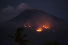 Mt Agung spews black smoke as eruption continues