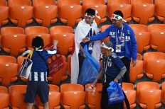 Japan fans use plastic bags to remove garbage at the end of the 2018 World Cup Group H football match between Japan and Senegal at the Ekaterinburg Arena in Ekaterinburg, Russia, on June 24, 2018.