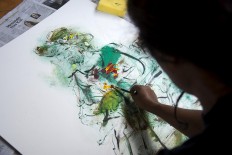 Nasirun shows students how to paint a model. JP/Tarko Sudiarno