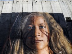A picture taken on July 29, 2018 shows a view of a mural painted on Israel's controversial separation barrier in the West Bank city of Bethlehem, by Italian artist Jorit Agoch, depicting Palestinian teenager Ahed Tamimi. Tamimi, who has become a Palestinian symbol for the struggle against the Israeli occupation, was released from prison on July 29 after nearly eight months. Agoch was arrested the day before for 'vandalising' the barrier.