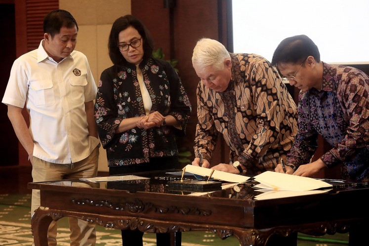 Bigger share: Freeport-McMoRan Copper & Gold Inc. CEO Richard Adkerson (second right) and PT Indonesia Asahan Aluminium (Inalum) president director Budi Gunadi Sadikin (right) sign a divestment agreement, witnessed by Energy and Mineral Resources Minister Ignasius Jonan (left) and Finance Minister Sri Mulyani in Jakartra on Thursday, July 12, 2018. The government, through Inalum, will have a 51 percent stake in PT Freeport Indonesia following the agreement. JP/Dhoni Setiawan