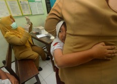 A student embraces her teacher while receiving a diphtheria vaccine during the final round of the Outbreak Response Immunization (ORI) program in Malang, East Java, on Tuesday, July 24, 2018. The program targeted local residents ranging in age from 1 to 19. JP/Nedi Putra AW