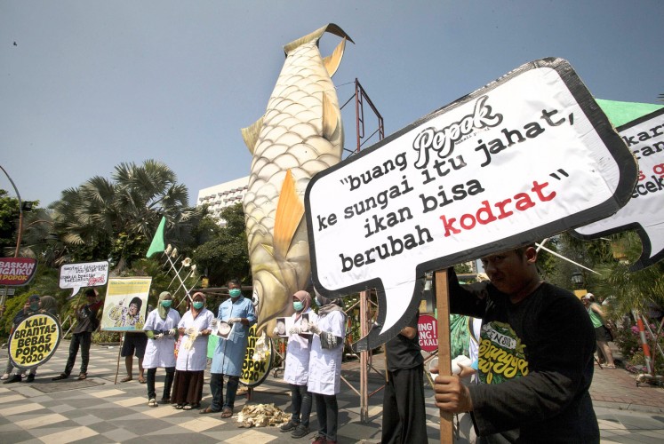 Demanding clean water: Conservation researchers stand in front of a giant model of a fish on Tuesday during a protest against what they say is the local administration’s lack of concern over preservation of the Brantas River, which is polluted with used diapers, at Grahadi City Hall in Surabaya, East Java. 