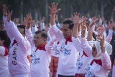President among 65,000 who dance 'poco-poco' to welcome Asian Games