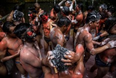 Young people wash their hair and bodies to clean off paint after the Ngarebeg ritual. JP/Agung Parameswara