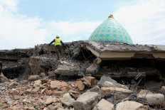 A rescuer searchers for victims feared to be buried under the rubble of Jamiul Jamaah Mosque in Pamenang village, North Lombok, on Wednesday Aug. 8, 2018. JP/Seto Wardhana