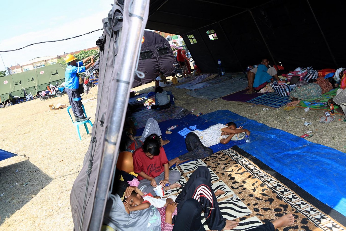 Indonesia quake toll jumps to 164, survivors wait for aid
