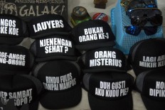 Black hats with catchy phrases attract buyers. JP/Tarko Sudiarno