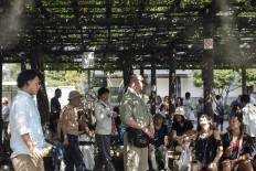 Tourists take a break in the shade at Sensoji Asakusa Temple in Tokyo. JP/Rosa Panggabean