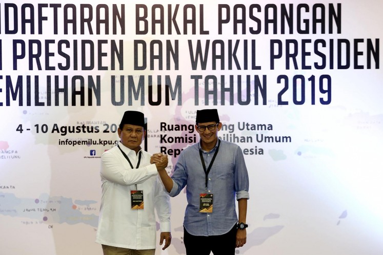 Gerindra Party chairman Prabowo Subianto (left) and former Jakarta deputy governor Sandiaga Uno clasp hands after registering their candidacy in the 2019 presidential election with the General Elections Commission (KPU) on Aug. 10, 2018.