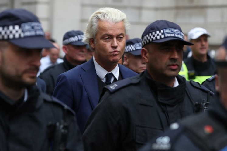 Dutch far-right PVV party leader Geert Wilders (C) is escorted away by police after speaking at a gathering of supporters of British far-right spokesman Tommy Robinson in central London on June 9, 2018, following the jailing of Robinson for contempt of court. 
Daniel LEAL-OLIVAS / AFP