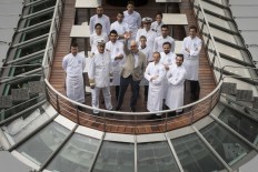 French chef Alain Ducasse (C) waves as he poses with his team on his new boat restaurant, the 'Ducasse sur Seine' on August 30, 2018 in Paris.