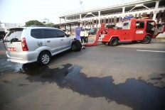 A towing car gives service to a troubled car in Jakarta. JP/Dhoni Setiawan