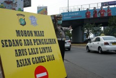 A police officer gives direction to motorists following to road restriction ahead of the Games closing ceremony in Jakarta. JP/Umair Rizaludin