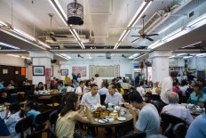 In this photo taken on August 7, 2018, diners share tables as they eat dim sum at the Lin Heung Tea House in Hong Kong.