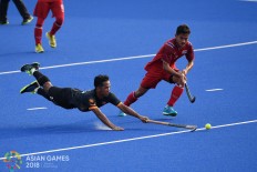 Malaysia's Faizal Saari (L) and Thailand's Boonmee (R) fight for the ball during the men's hockey pool B match between Malaysia and Thailand at the 2018 Asian Games in Jakarta on August. 22.Inasgoc via Antara/ Dhoni Setiawan