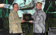 Anniversary gift: Rector of Indonesia Open University (UT) Ojat Darojat (right) hands over a book titled Indonesia Open University 34 years old: Cyber University for the Country to Research, Technology and Higher Education Minister Mohamad Nasir during the 34th Dies Natalis celebration at the UT Convention Center building in Banten, South Tangerang, on Tuesday.
