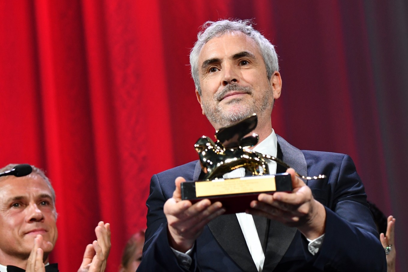 Director Alfonso Cuaron (C) poses as member of the Venezia 75 competition jury, Austrian-German actor Christoph Waltz applauds, after receiving the Golden Lion award for Best Film for the movie 'Roma' during the awards ceremony of the 75th Venice Film Festival on September 8, 2018 at Venice Lido.