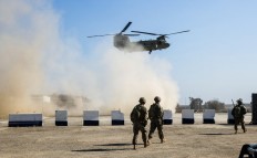 US troops patrol as a US Army C-47 Chinook helicopter flies over the village of Oreij, south of Mosul where a temporary military base has been established for an assault on the city's west bank. The White House on September 11, 2018, warned it would hold Iran accountable for any violence attributed to Tehran-allied militias in Iraq that results in damage to US facilities or injures American personnel. 