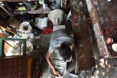 Bringing to life: Deny from the Al-Fathir ondel-ondel workshop works on a face of a traditional Betawi ondel-ondel fi gure in Kramat Pulo, Central Jakarta. JP/David Caessarre