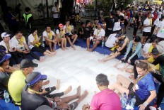 Cooling down: Runners lay their feet on ice cubes to reduce aches and stiffness upon completing the 2018 Maybank Bali Marathon on Sept. 9 in Gianyar, Bali.
