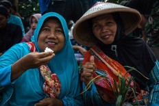 Two villagers enjoy eating together. JP/Anggertimur Lanang Tinarbuko