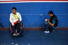A wheelchair fencer waits for his sword to be fixed. JP/Maksum Nur Fauzan