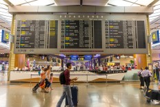 Visitors walk around Departure Hall in Changi Airport. 
