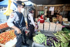 Police officers stand guard at the Masomba traditional market in Lolu subdistrict, South Palu, on Thursday, October 4, 2018. . Slowly, local economic activity has resumed in the city. JP/Dhoni Setiawan