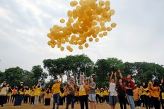 Shared concern: Anyo Gold Ribbon Configuration participants release yellow balloons into the air to show their support for children with cancer.