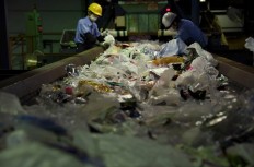 Workers sort disposable garbage from plastic recyclable resources on the conveyor belt at Ichikawa Kankyo Engineering recycle centre in Narashino, Chiba. Plastic waste has been piling up in Japan since China's new policy came into force.