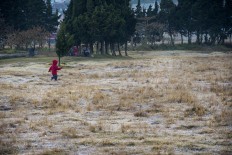 A children runs around at the Arjuna temple complex while enjoying the cold weather. JP/Tarko Sudiarno