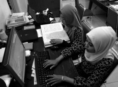 The rewriting process is done in pairs. One staff member reads while another types. JP/Ganug Nugroho Adi